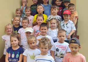 Dzieci ustawione na stopniach schodów przed wejściem do szatni.