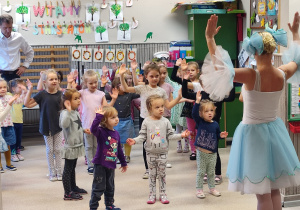 Wszystkie dziewczynki na scenie. Podnoszą ręce tak, jak pokazuje baletnica.