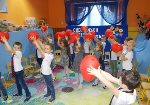 Wszystkie dzieci unoszą razem balony raz w lewą raz w prawą stronę.