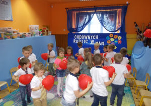 Dzieciaki biegną po kole trzymając swoje balony. W środku jest koło dziewczyn, na zewnątrz chłopców.