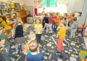 Dzieci na dywanie. Poruszają się w różne strony w rytm muzyki.