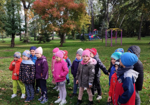 Dzieci spacerują po szkolnym jesiennym parku i placu zabaw.
