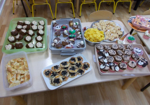 Na stole rozłożone przekąski: mufinki jak duszki, pizzerinki z pajączkami z oliwek.